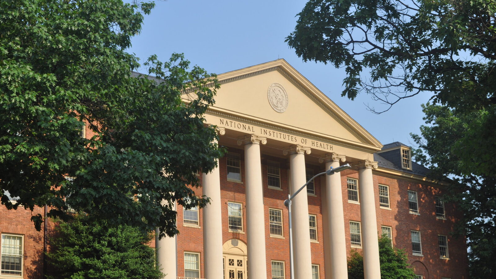 A big brick building with columns. An inscription at the top reads "National Institutes of Health."