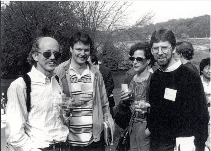A black and white photo of four scientists on the grass at a scientific conference in 1993.