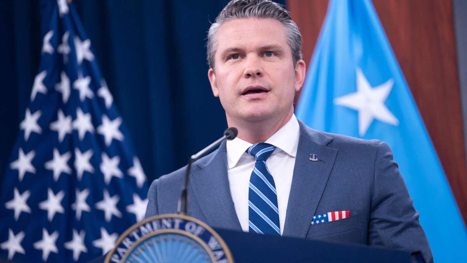 Defense Secretary Pete Hegseth speaks at a podium. 