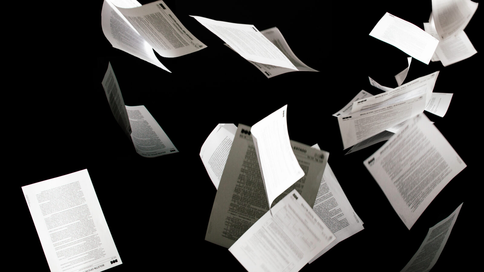 Many flying business documents isolated on black background.