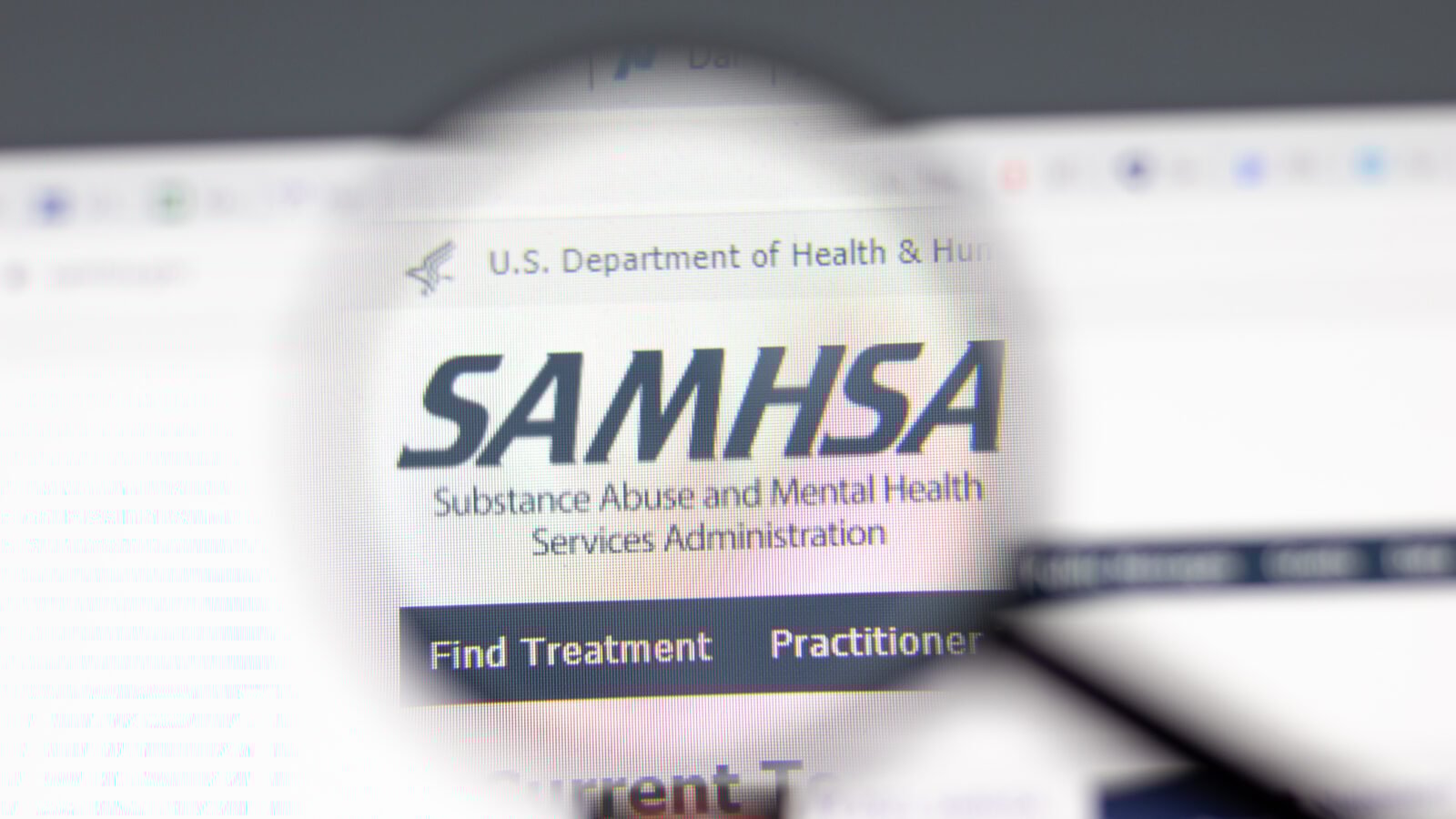 A microscopic lens encircles the SAMHSA logo on a webpage.