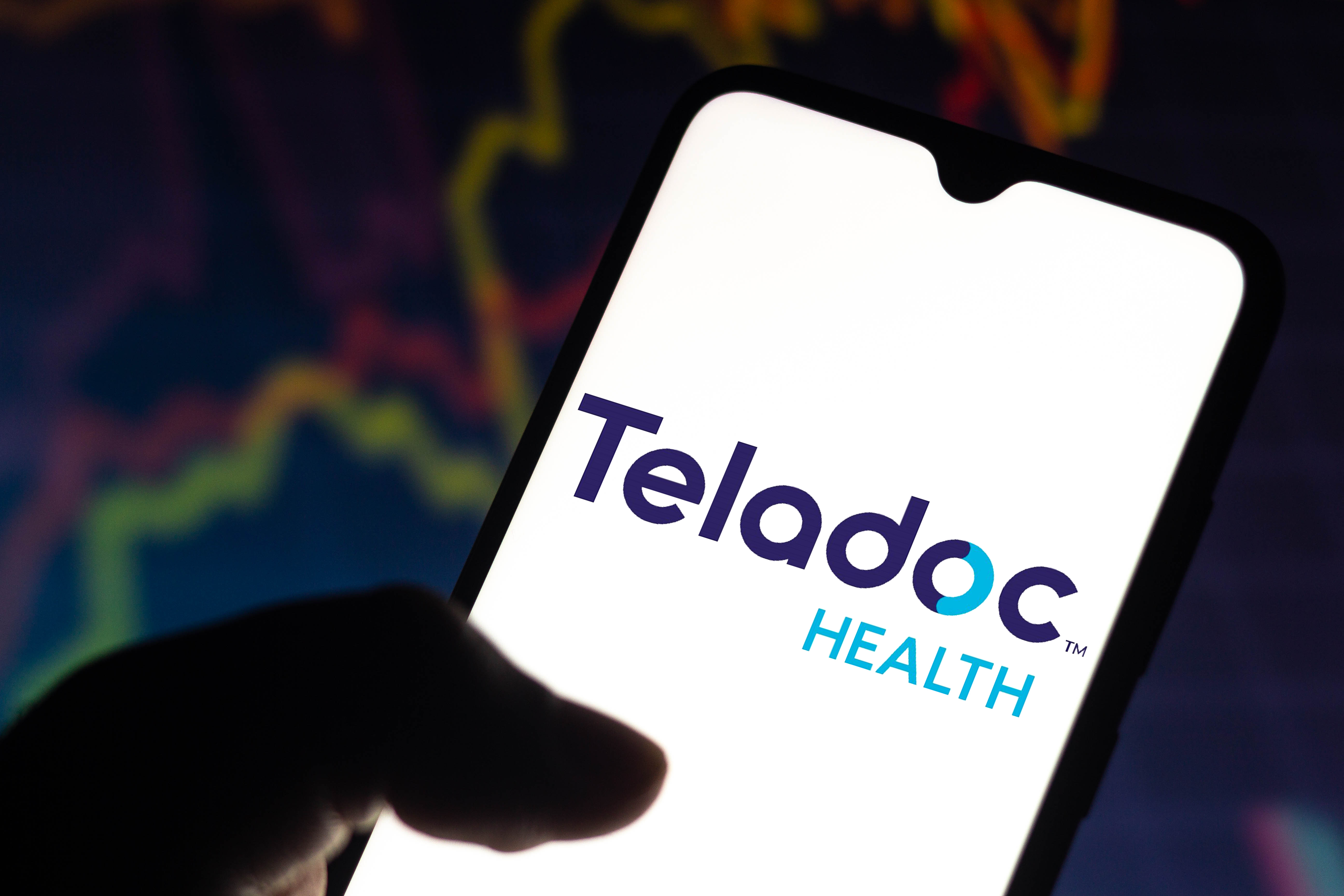 The Teladoc Health logo on a glowing smartphone screen