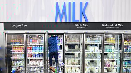 someone loading the milk aisle in a grocery store