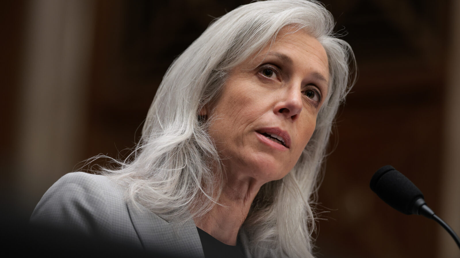 Former CDC Director Susan Monarez talks in front of a microphone while wearing a grey blazer