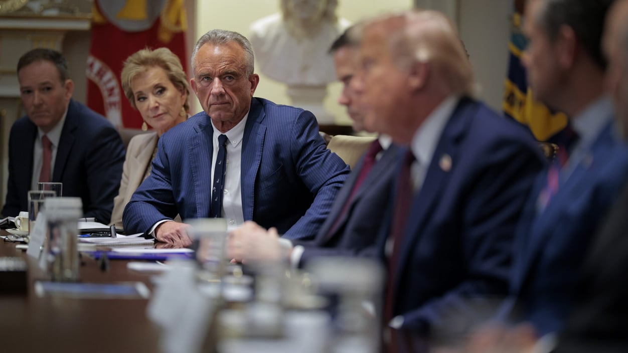 Health secretary Kennedy stares down a long conference room table at President Trump.