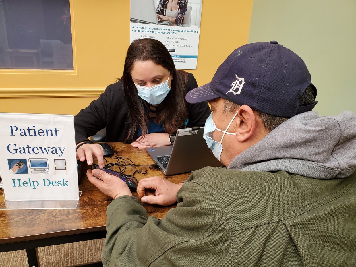 Janelle Vargas, a Digital Access Coordinator at Pentucket Medical Riverwalk, helps Herman Quintero navigate digital health tools on his phone.