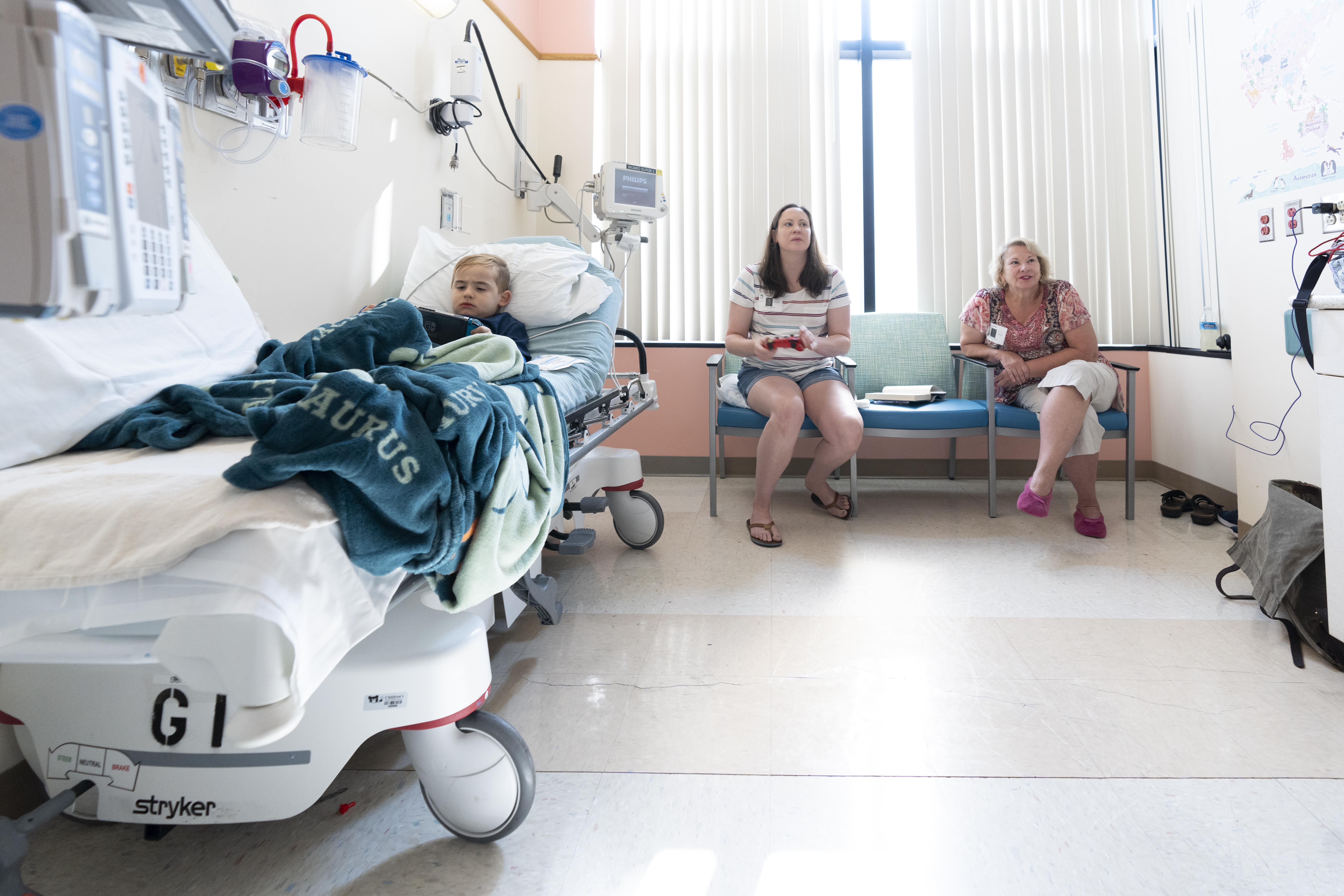 Hiram Secrist sits in a hospital bed next to his mother, Kristen Secrist, and his grandmother, Terrie Jordan.