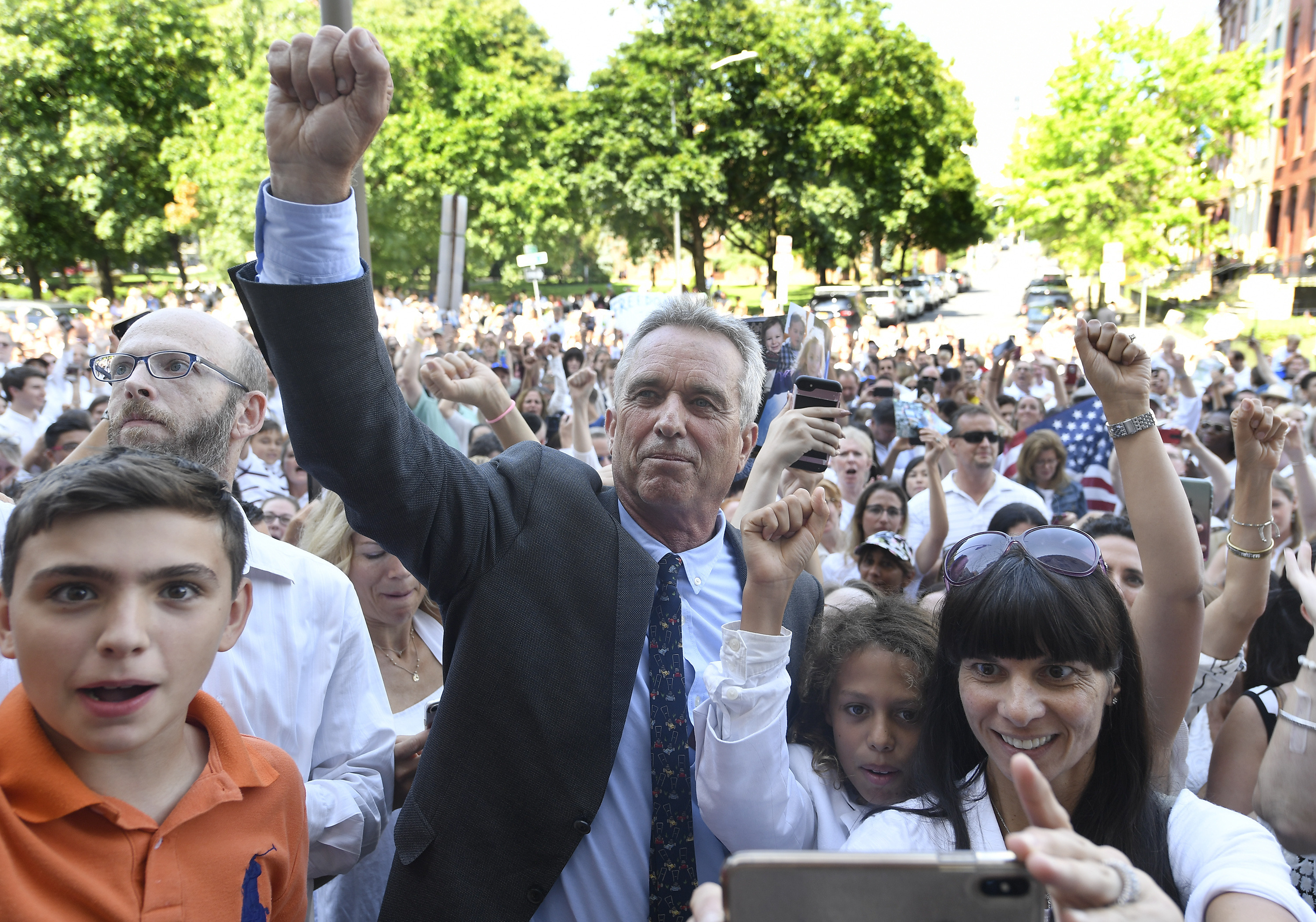 Robert F. Kennedy, Jr. holds his first in the air as he poses for photographs with fans