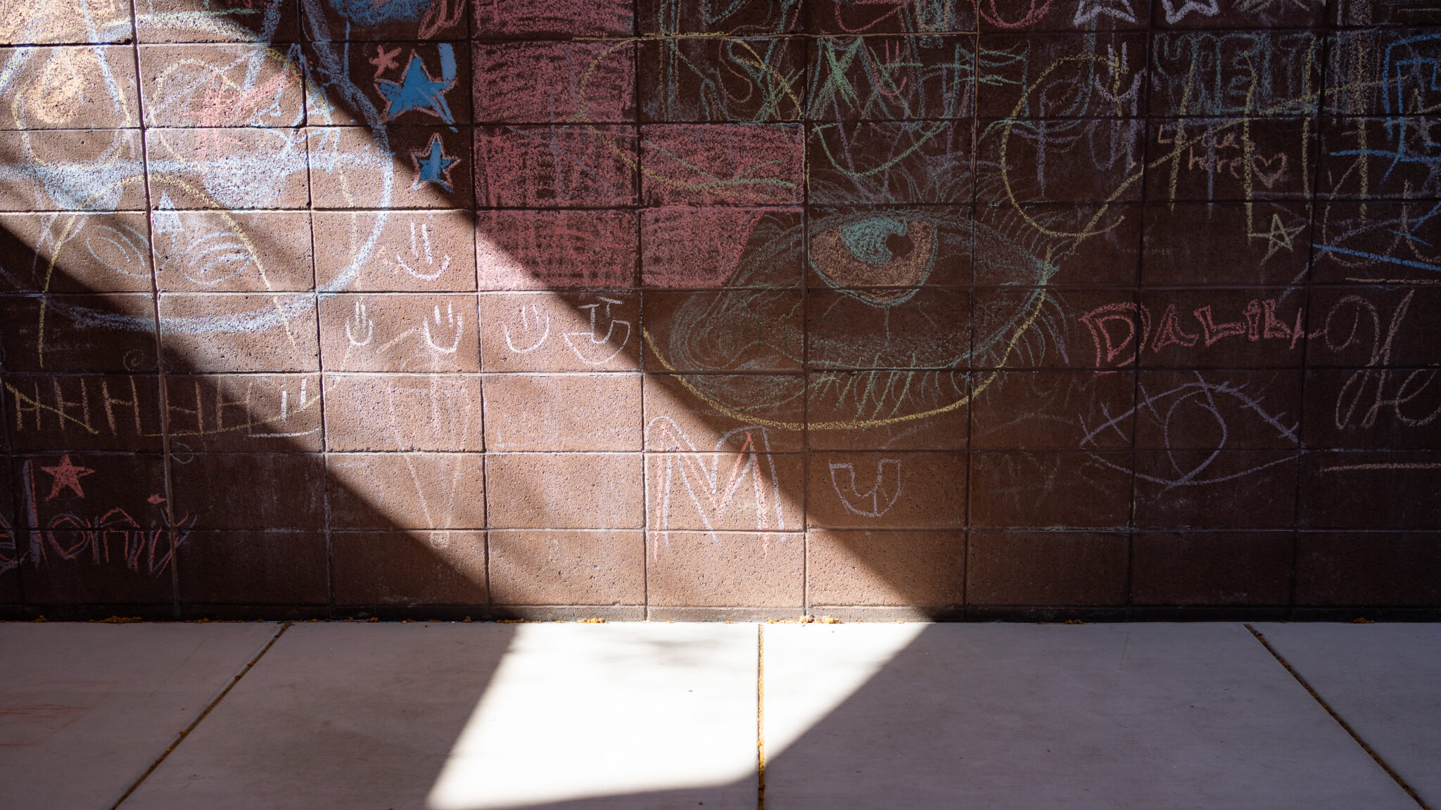 Colorful chalk drawings are shown on a wall in a outdoor area at Connections Health Solution's Crisis Response Center in Tucson, Arizona.
