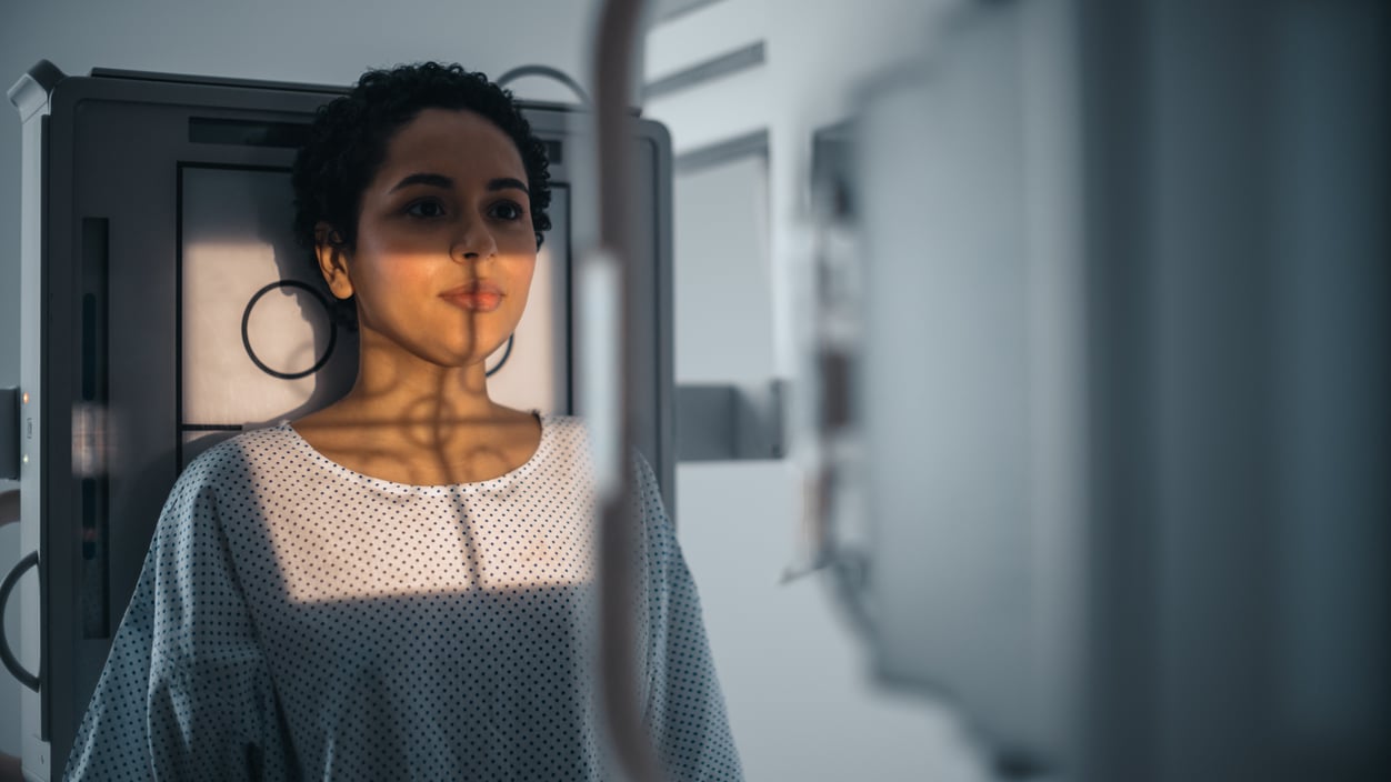 Photo of a woman standing in front of an x-ray machine