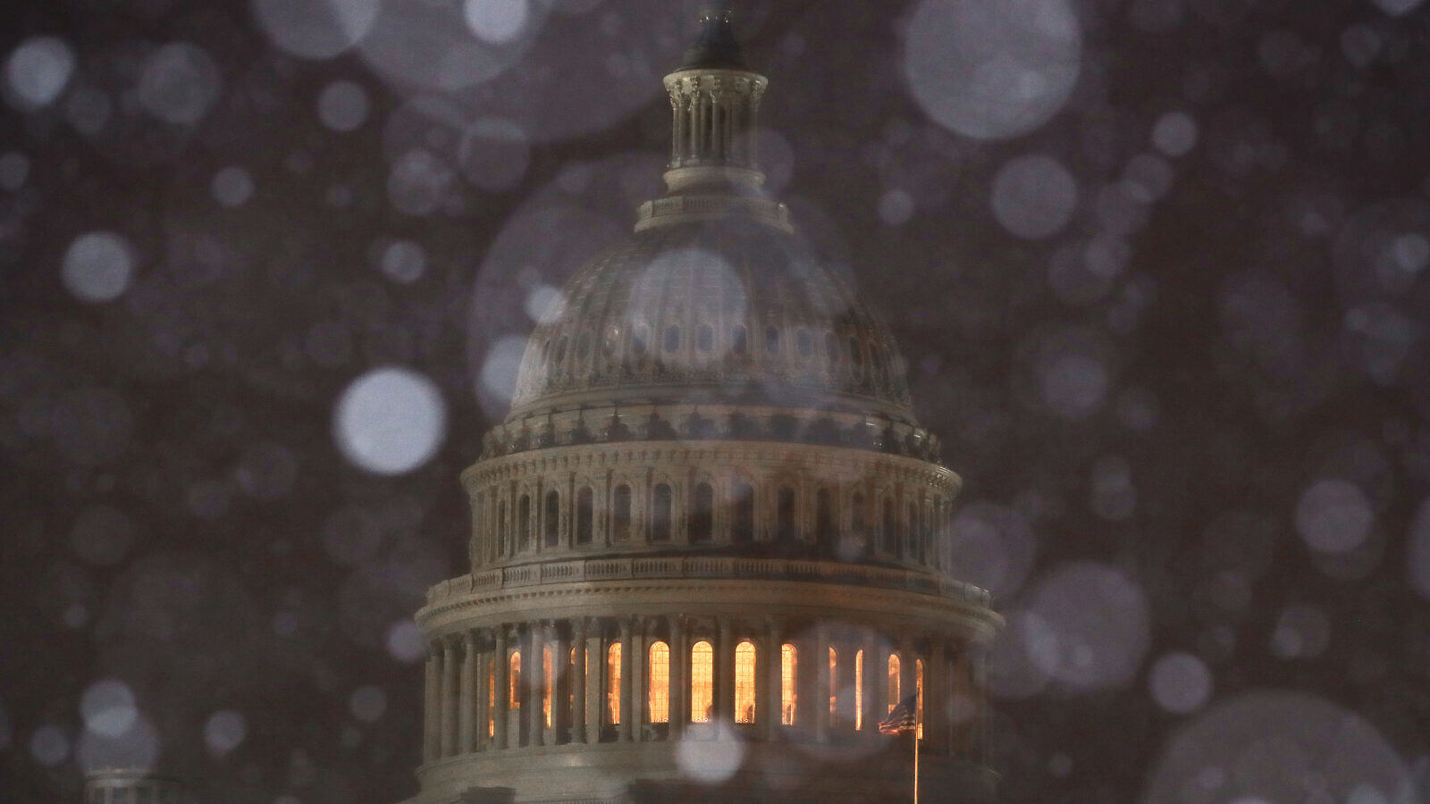 A file news photo of snow falling at night on the U.S. capitol building dome in Washington D.C.