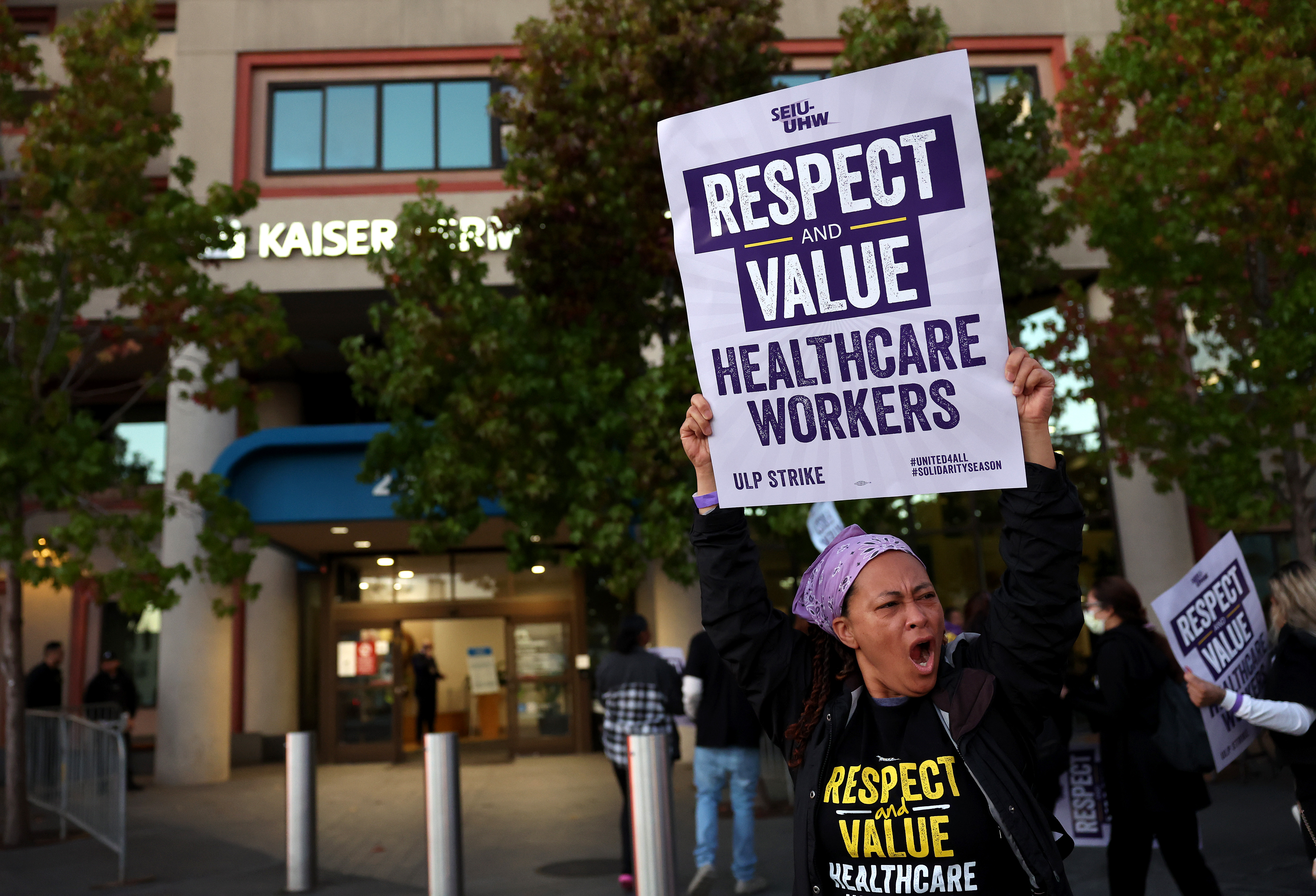 Striking Kaiser Permanente workers hold signs as they march in front of the Kaiser Permanente San Francisco Medical Center on October 04, 2023 in San Francisco. The sign reads, "Respect and value healthcare works."