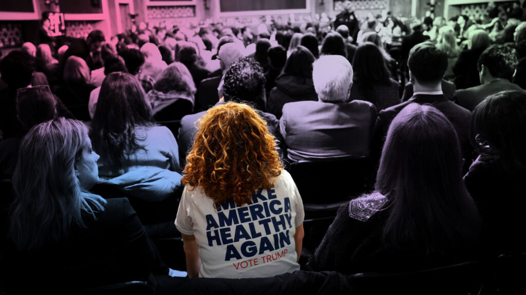 Someone sits in a crowd wearing a "Make America Healthy Again Vote Trump" tshirt