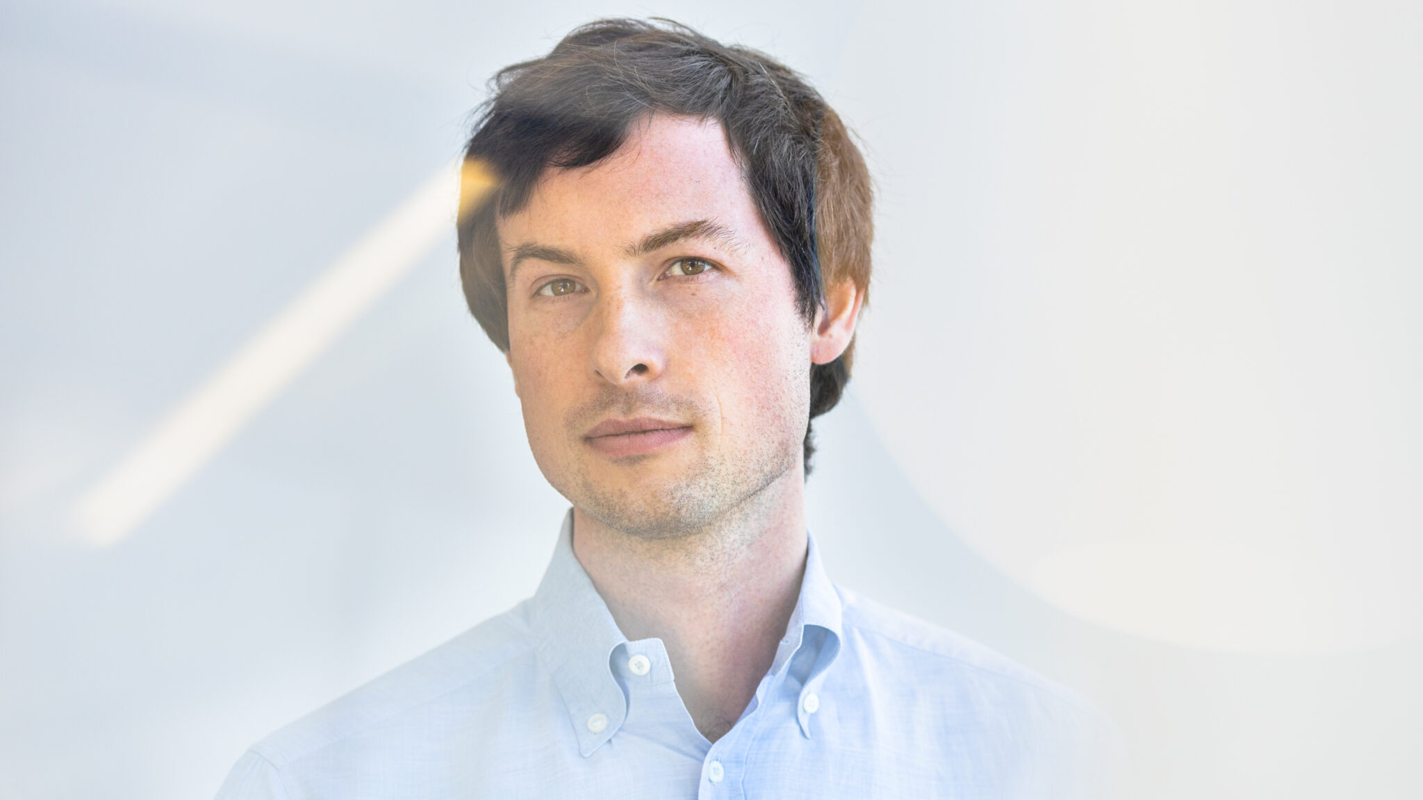 A portrait of Reed Jobs, who is wearing a blue button-down shirt.