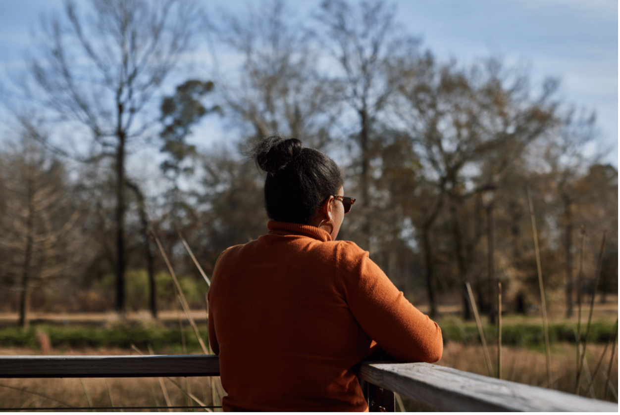 Photograph of an unidentified woman looking out at a pond