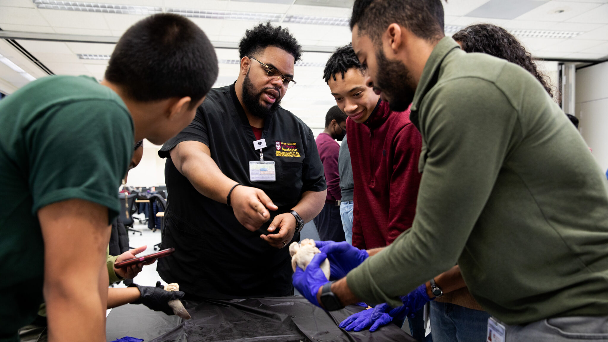 Emergency room physician Abdullah Pratt teaches high school students about the anatomy of a sheep heart in the MedCEEP program he founded at the University of Chicago.