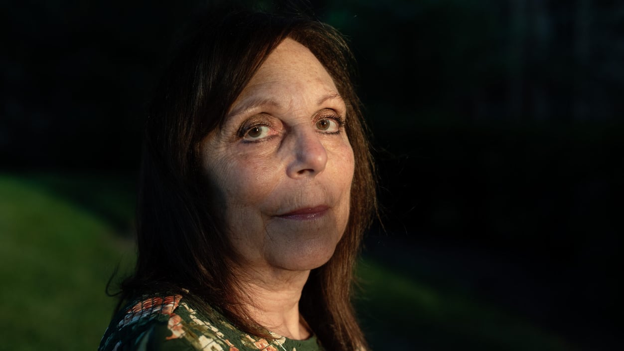 A close up of Ellyn Kodroff, who look sstraight at the camera, with her face half lit by the sun.